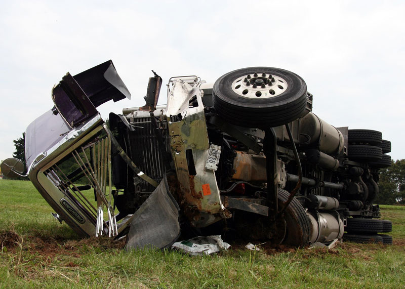 Work truck off the road on its side Work truck off the road on its side